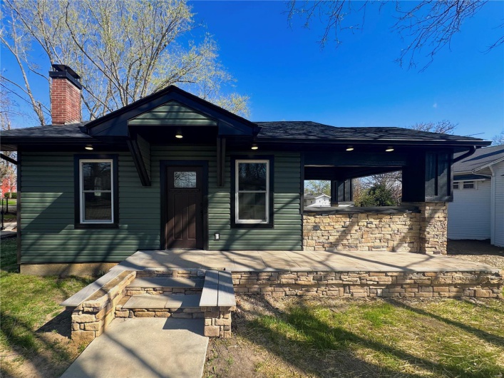 View of front of property with a chimney and a shingled roof