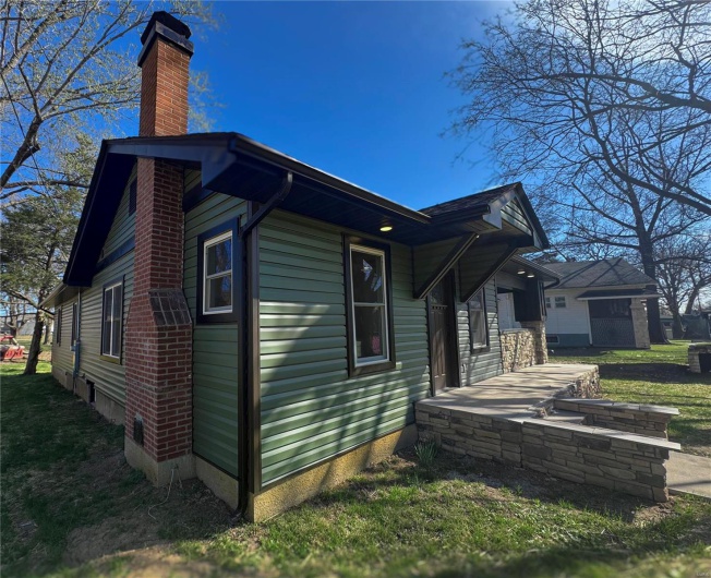 View of side of home featuring a chimney