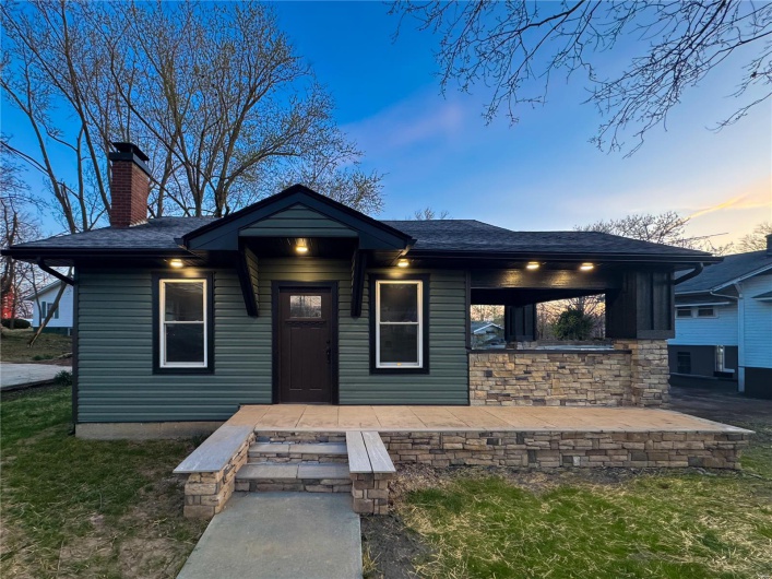 View of front of home with roof with shingles and a chimney