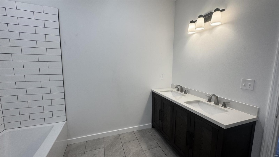 Bathroom with baseboards, double vanity, and a sink