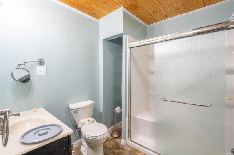 Full bathroom with vanity, baseboards, a stall shower, wood ceiling, and toilet