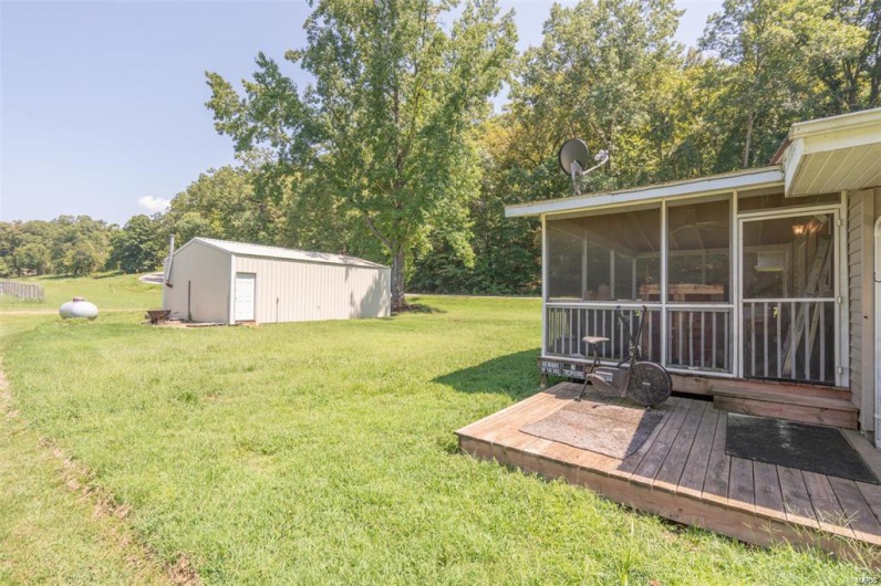 View of yard featuring an outdoor structure and a sunroom