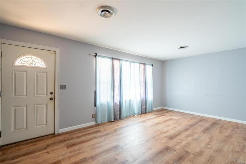 Entrance foyer featuring visible vents, wood finished floors, and baseboards