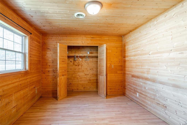 Unfurnished bedroom with a closet, visible vents, light wood-style flooring, and wooden ceiling