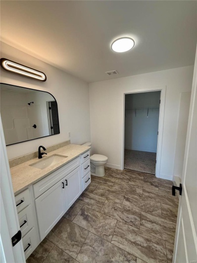 Bathroom featuring visible vents, baseboards, toilet, and vanity