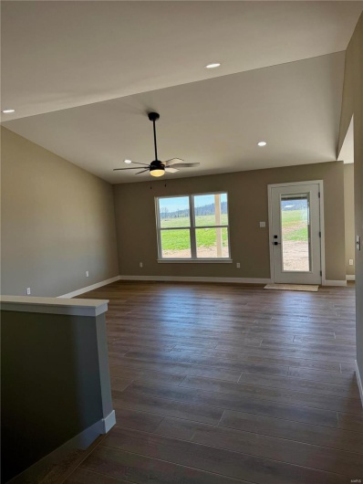 Unfurnished living room featuring recessed lighting, baseboards, dark wood-type flooring, and a ceiling fan