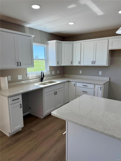 Kitchen featuring light stone countertops, recessed lighting, a sink, dark wood-type flooring, and white cabinetry