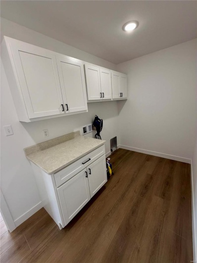 Laundry room with baseboards, cabinet space, hookup for a washing machine, and dark wood-style flooring