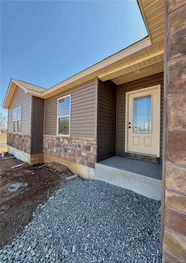Doorway to property featuring stone siding