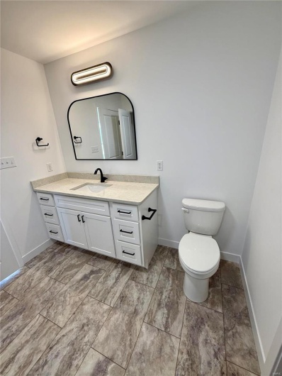Bathroom with vanity, toilet, and baseboards