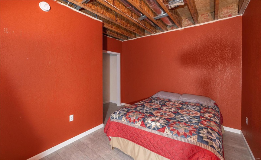 Bedroom featuring wood finished floors and baseboards
