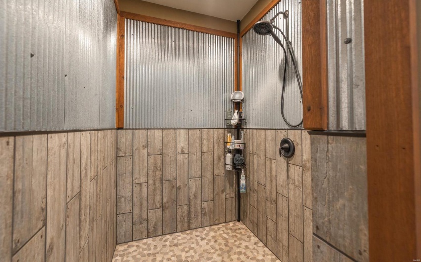 Bathroom with a wainscoted wall and a tile shower