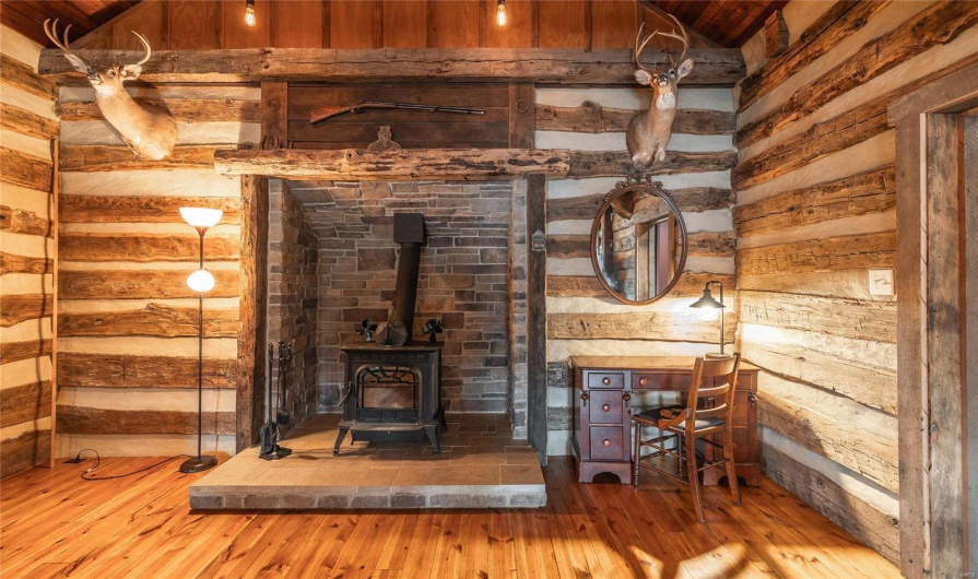 Room details with a wood stove and wood finished floors