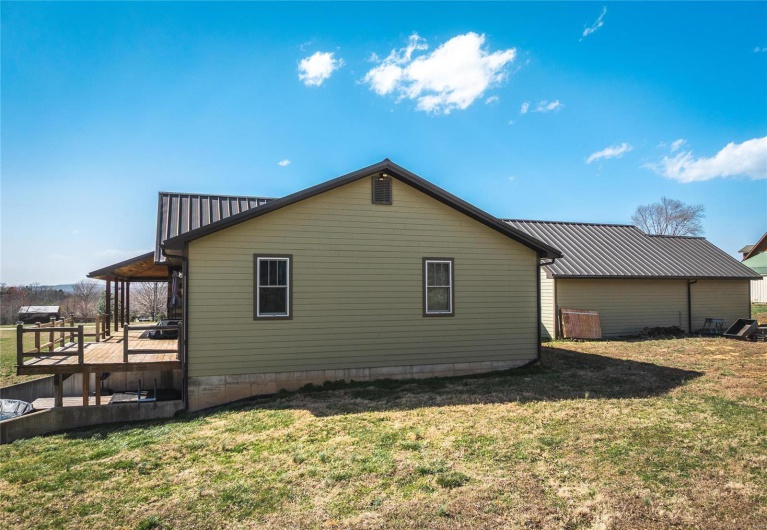 View of home's exterior with a lawn and a wooden deck