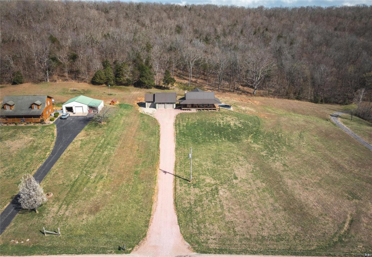 Birds eye view of property featuring a rural view and a wooded view