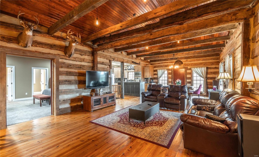 Living room with beam ceiling, wood walls, wooden ceiling, and hardwood / wood-style flooring