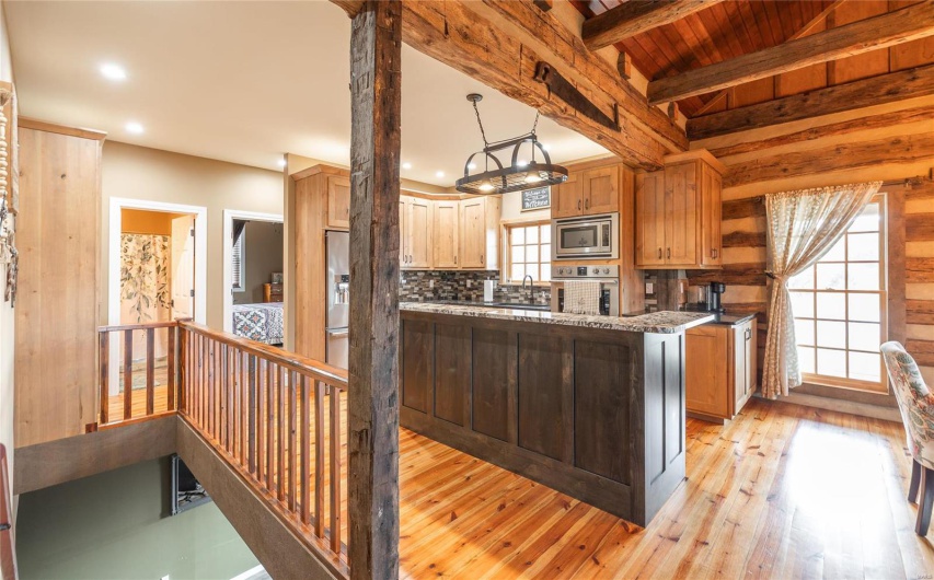 Kitchen with beam ceiling, light wood-style flooring, backsplash, recessed lighting, and stainless steel appliances