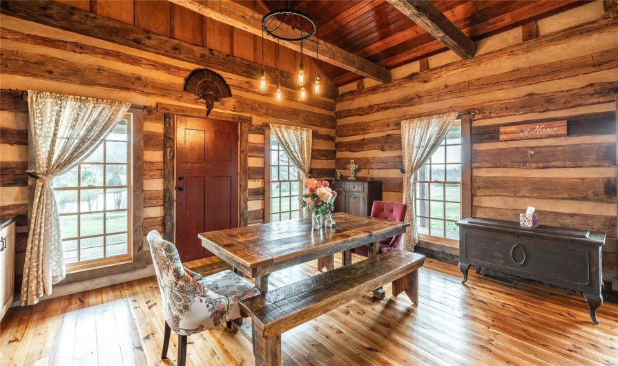 Dining room featuring wooden walls, wooden ceiling, lofted ceiling with beams, and hardwood / wood-style floors