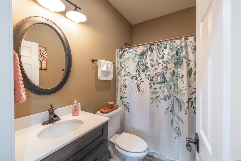 Bathroom featuring a shower with curtain, toilet, and vanity