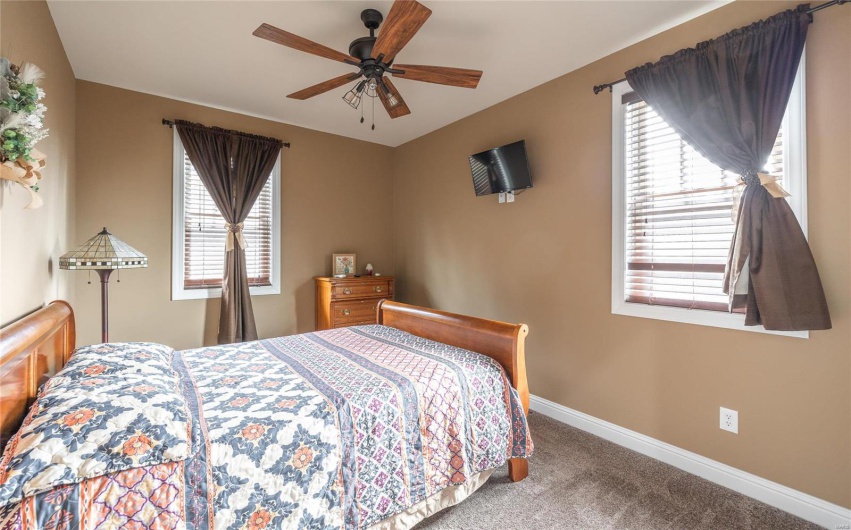 Bedroom with multiple windows, ceiling fan, baseboards, and carpet floors
