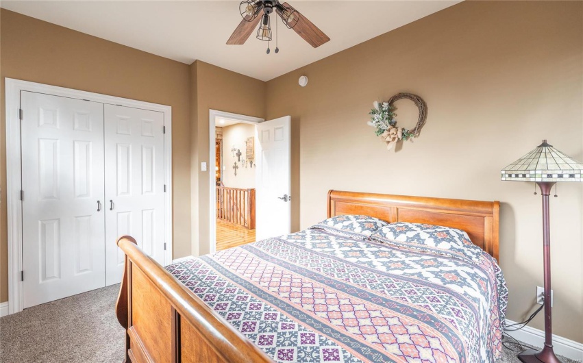 Carpeted bedroom with a closet and ceiling fan