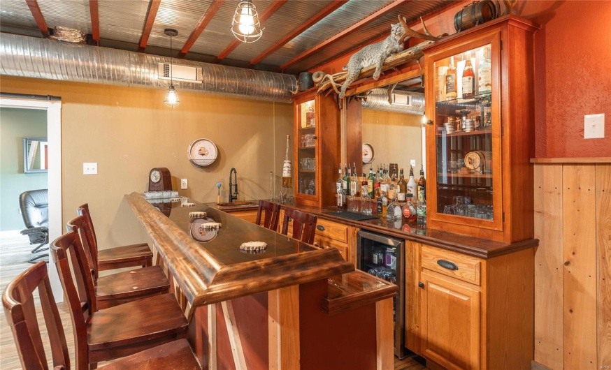 Bar with wine cooler, visible vents, wet bar, and a sink