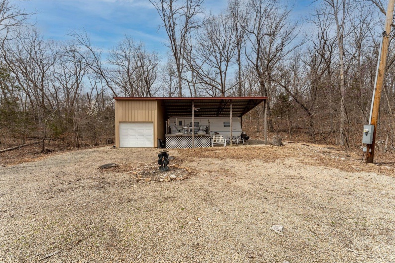 View of pole building with an attached garage and dirt driveway