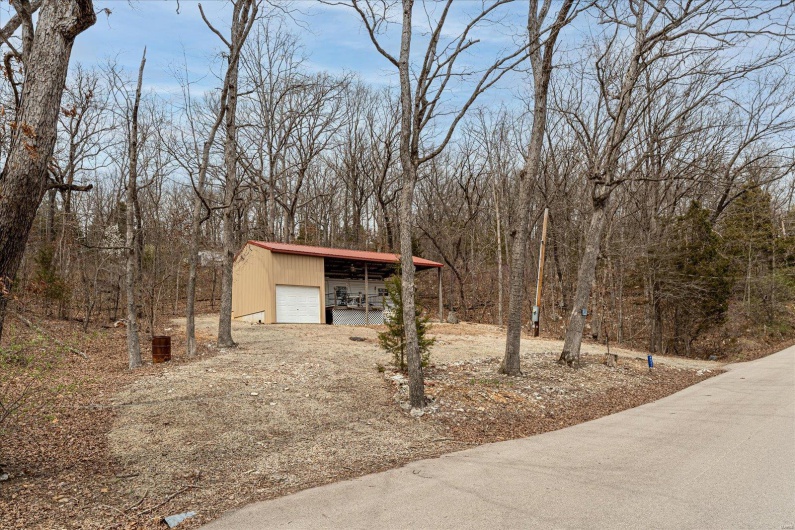 View of yard featuring an outdoor structure and dirt driveway