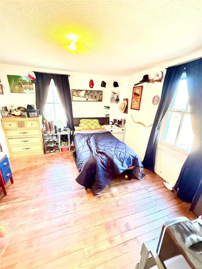 Bedroom featuring a textured ceiling and hardwood / wood-style floors
