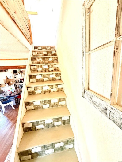 Stairs featuring wood finished floors
