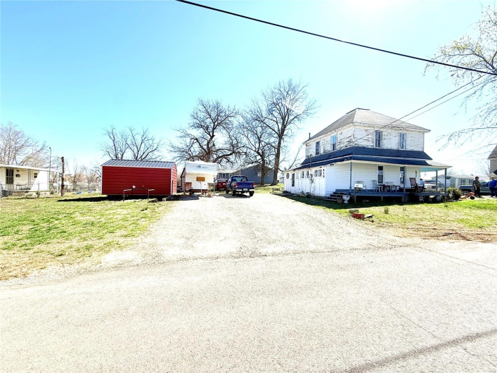 View of front facade with an outdoor structure and dirt driveway