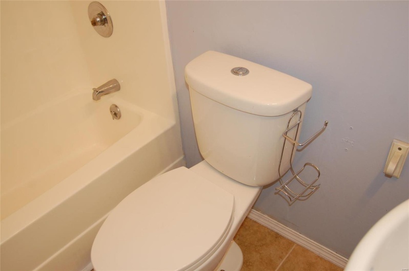 Bathroom with baseboards, toilet, and tile patterned flooring