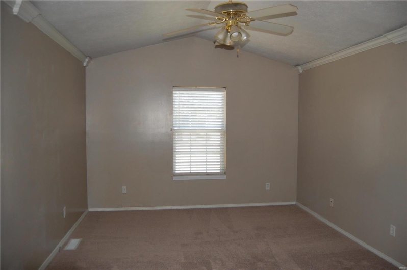 Empty room featuring baseboards, carpet floors, ornamental molding, and a ceiling fan