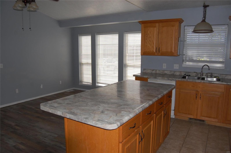 Kitchen with visible vents, ceiling fan, a kitchen island, a sink, and dishwashing machine