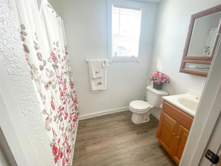 Full bathroom featuring a shower with shower curtain, vanity, baseboards, toilet, and wood finished floors