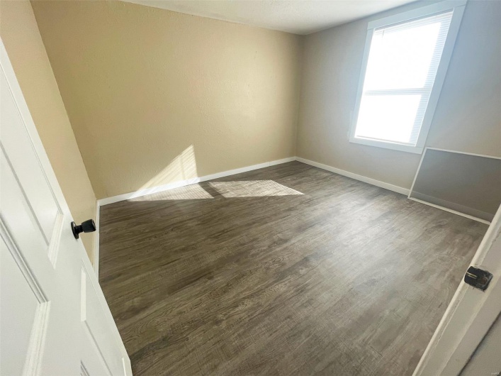 Unfurnished room featuring baseboards and wood finished floors