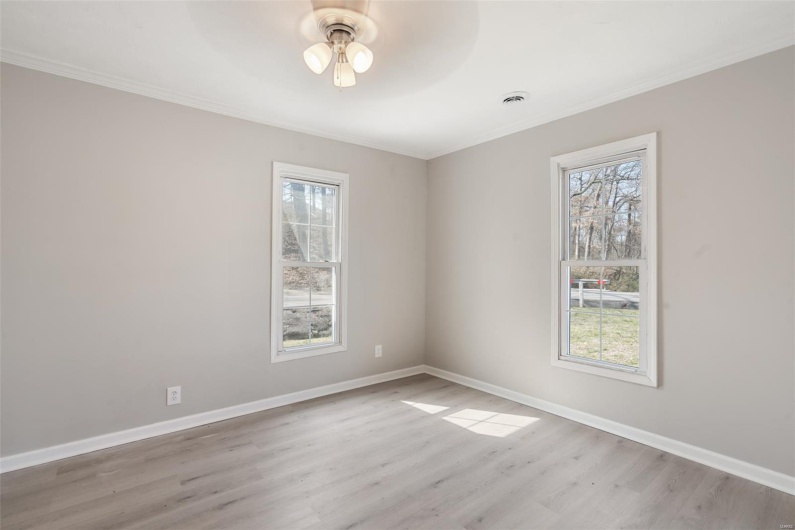 Spare room featuring a wealth of natural light, ceiling fan, and baseboards