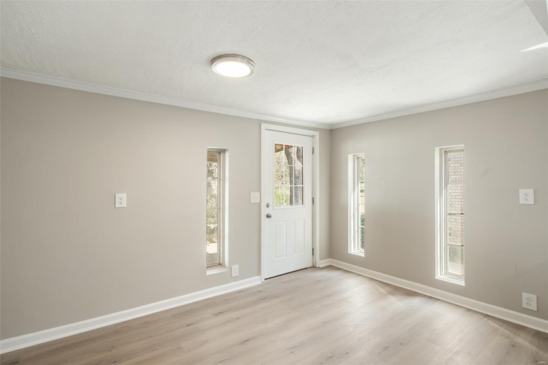 Entryway with baseboards, a textured ceiling, crown molding, and light wood-type flooring