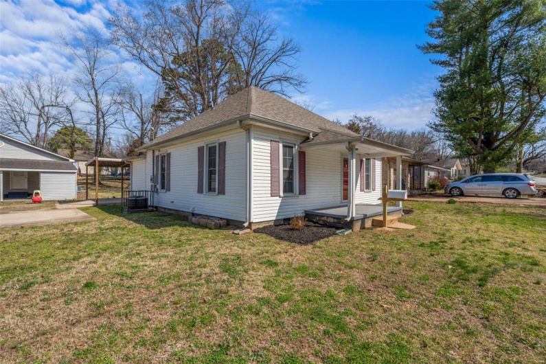 View of property exterior with a lawn, a shingled roof, and central AC unit