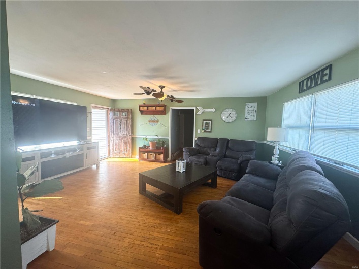 Living area with hardwood / wood-style flooring and ceiling fan