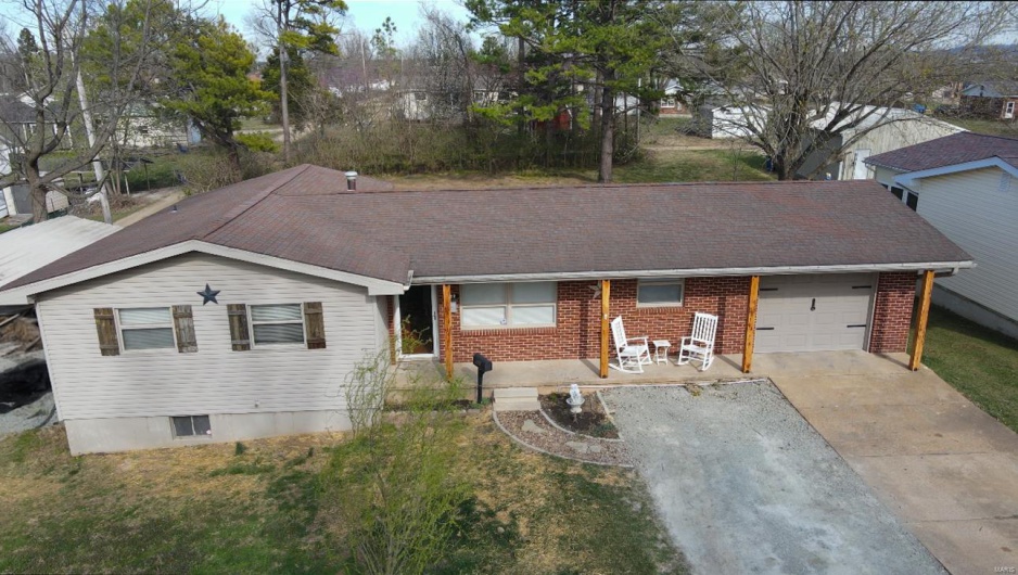 Single story home featuring an attached garage, brick siding, and concrete driveway