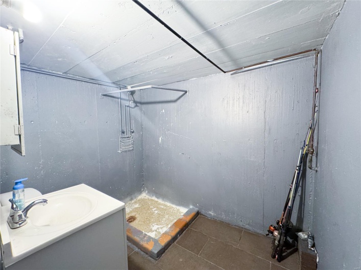 Bathroom featuring tile patterned floors, vanity, and a walk in shower