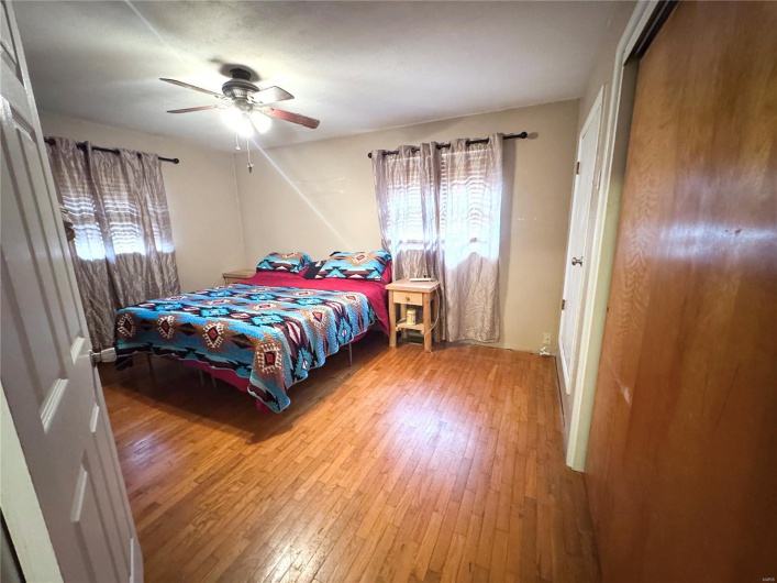 Bedroom featuring ceiling fan and hardwood / wood-style flooring