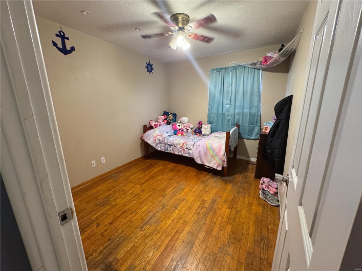 Bedroom featuring wood-type flooring, baseboards, ceiling fan, and a textured ceiling