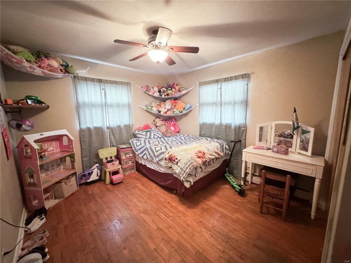 Bedroom with multiple windows, wood finished floors, and ceiling fan