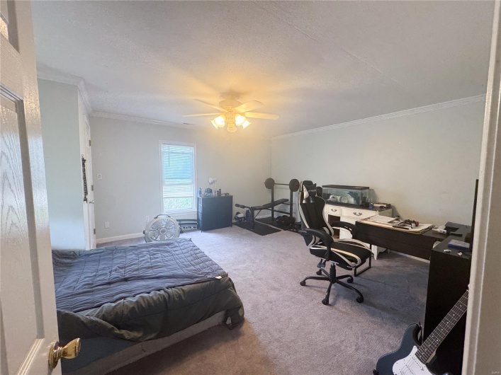 Bedroom with carpet floors, a textured ceiling, ceiling fan, and crown molding