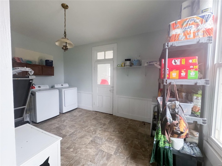Laundry area with a decorative wall, independent washer and dryer, a wainscoted wall, and laundry area