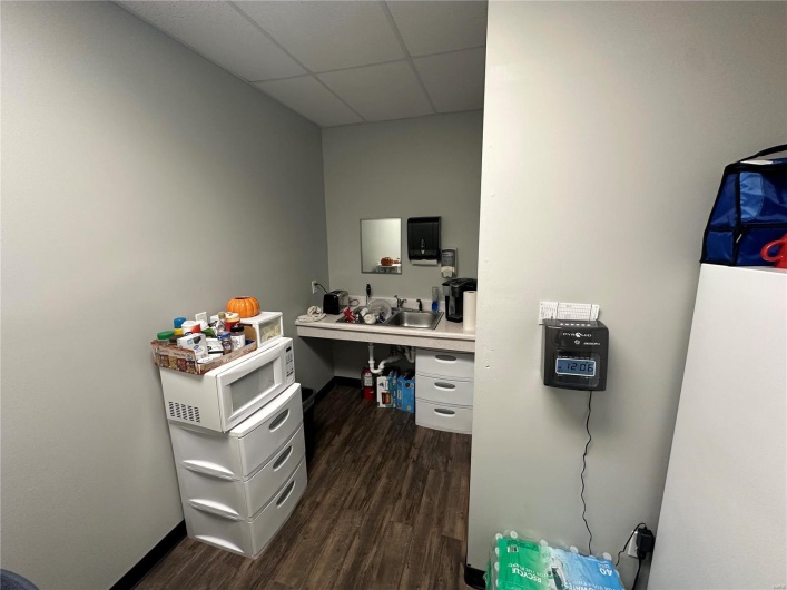 Office area featuring dark wood finished floors and a drop ceiling