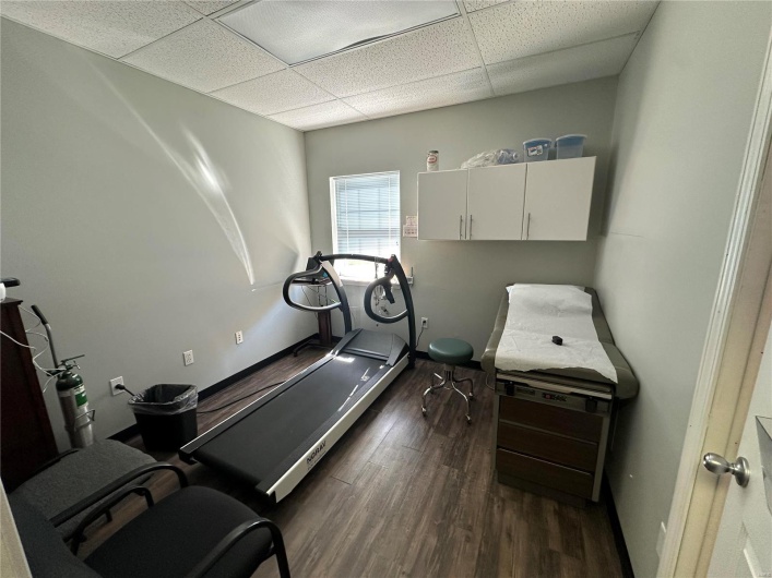 Exercise area with a drop ceiling, baseboards, and wood finished floors