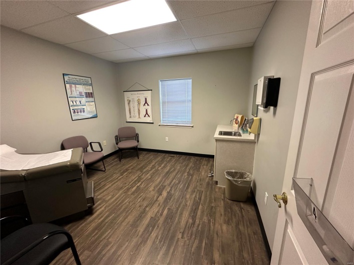 Office with a sink, baseboards, a paneled ceiling, and dark wood-style floors